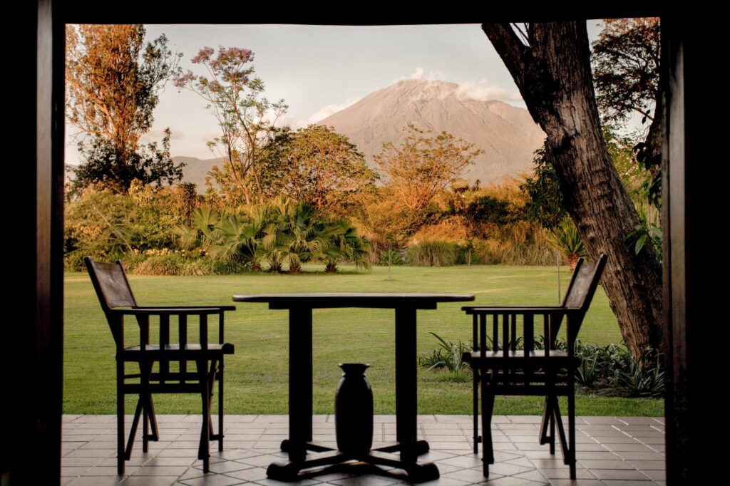 Veranda of Legendary Lodge with two chairs and a table with a mountain in the background