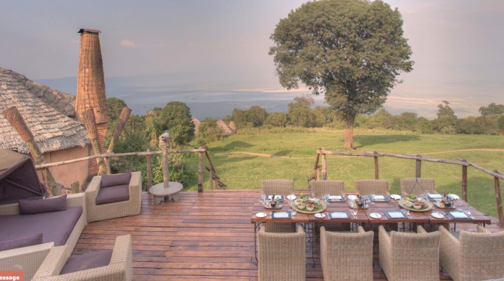 Ngorongoro Crater Lodge terrace with table and green scenery in front