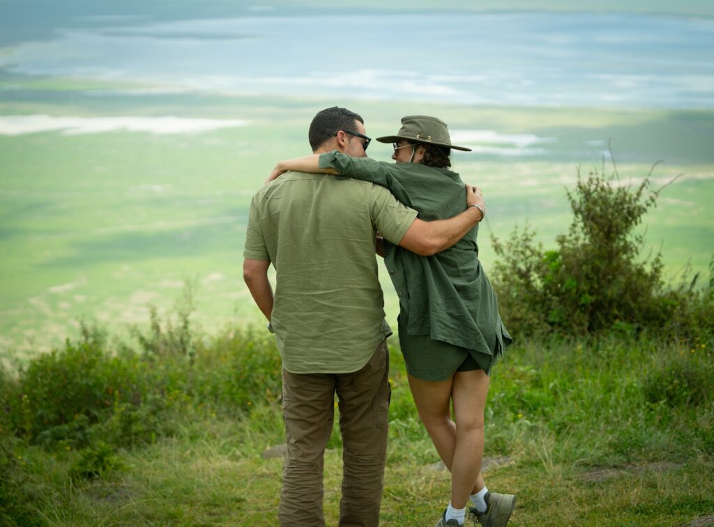 Couple standing on green hill looking down to green land