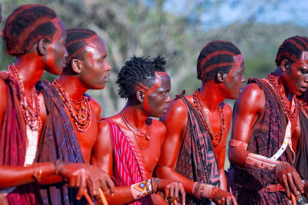 Guerreros masai con la piel de color rojo y ropas tradicionales