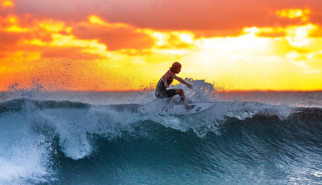 Woman surfing on a wave during sunset