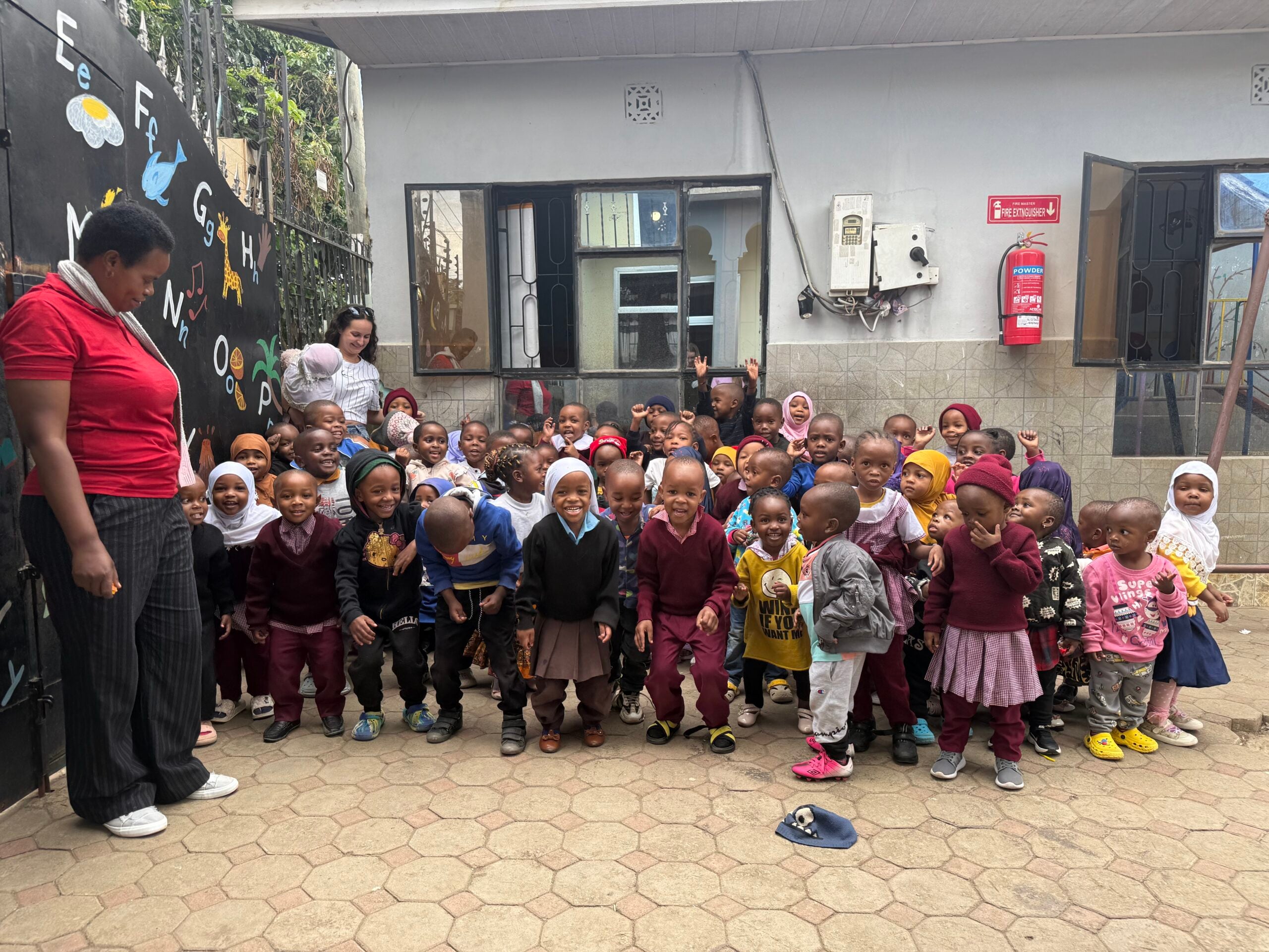 A group of kids of Daisy Daycare in Arusha, Tanzania, with a teacher on the left